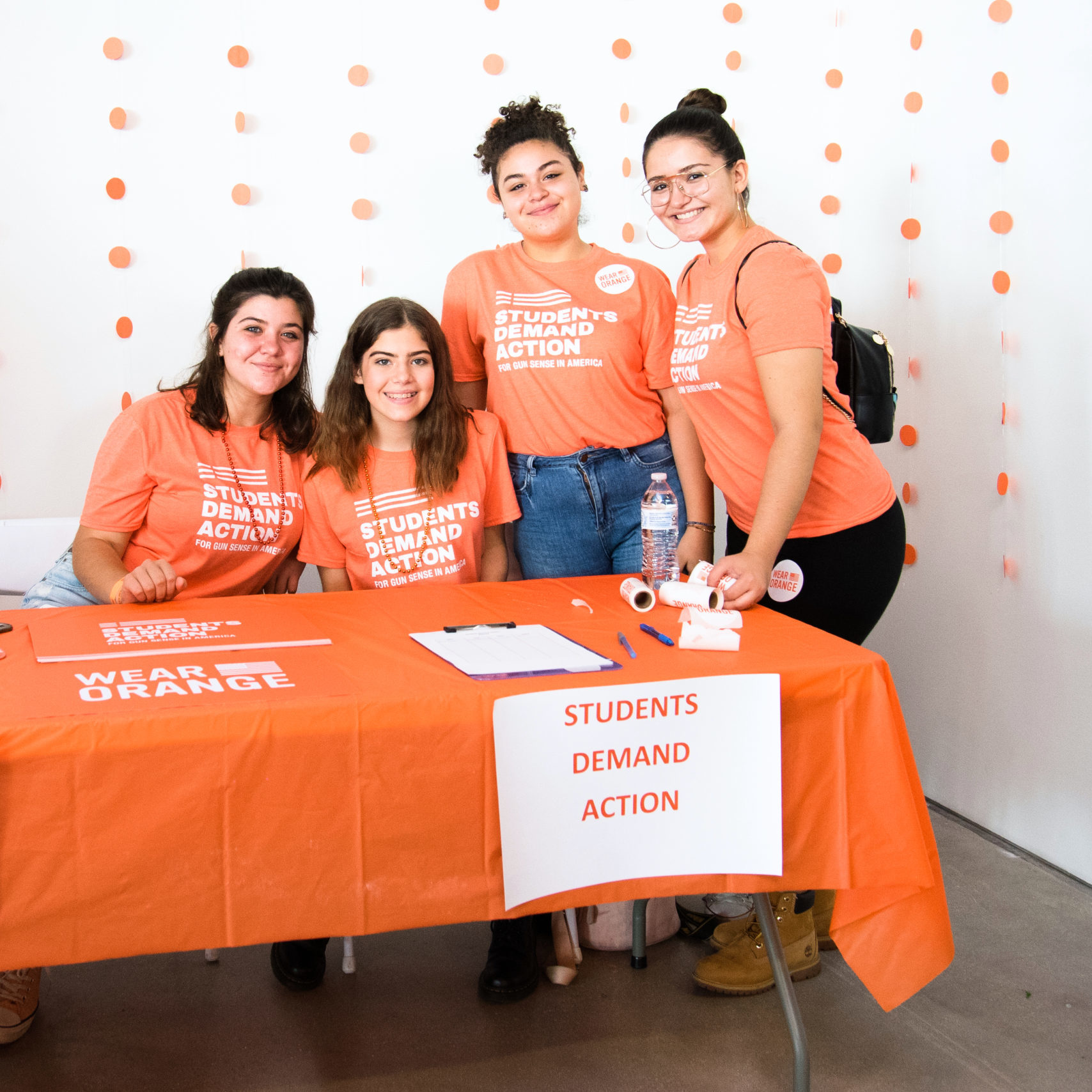 Students Demand Action volunteers tabling in orange t-shirts