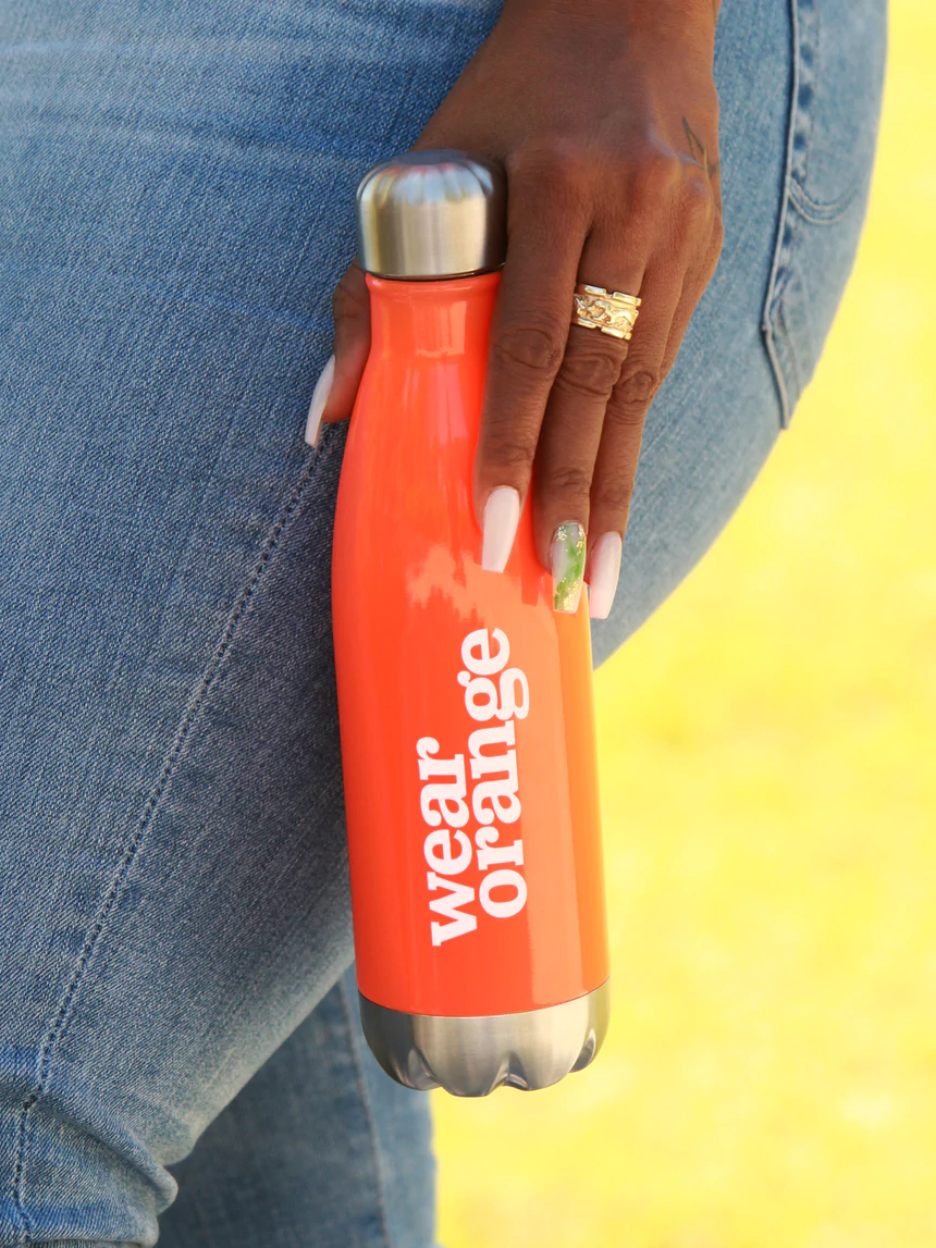 A person holds a Wear Orange water bottle